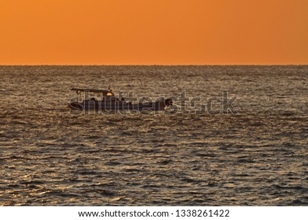 Collaboration of the sea and fishing boat stained at dusk