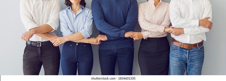 Collaboration, support, unity, solidarity concept. Team of workers holding hands ready to defend company interests and help each other. Business partners standing together. Banner, header, hero image