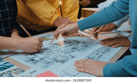 A collaborative design session where a diverse group engages with sketches and blueprints on a table, showcasing teamwork and innovative planning in an inspiring workspace. SACTR