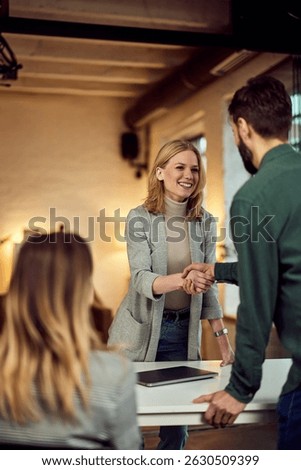 A collaborative handshake between colleagues in a professional work environment during negotiations.