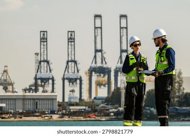 A collaborative meeting between project managers and engineers overseeing large-scale marine vessel refurbishments and technical upgrades at a busy shipyard.