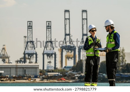 A collaborative meeting between project managers and engineers overseeing large-scale marine vessel refurbishments and technical upgrades at a busy shipyard.