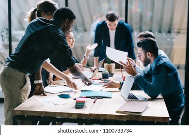 Collaborative process of multicultural skilled students during brainstorming meeting in office.Diverse team of young people dressed in formal wear cooperating on developing common design project - Shutterstock ID 1100733734