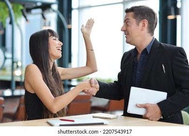 Collaborative process of professional businesspeople shaking hands after new business contract signed, using computer and smart mobile phone with happy face. Coworker and working together concept - Shutterstock ID 2207543917