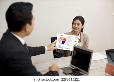 Collaborative process of professional businesspeople using paperwork and going over on meeting presentation with growth analysis, charts, statistics and data at office meeting concept.