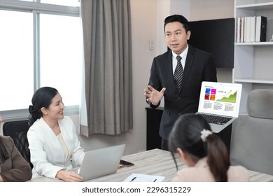 Collaborative process of professional businesspeople using computer and going over on meeting presentation with growth analysis, charts, statistics and data at office meeting concept.