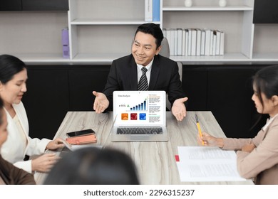 Collaborative process of professional businesspeople using computer and going over on meeting presentation with growth analysis, charts, statistics and data at office meeting concept.