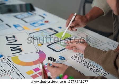 Collaborative UX UI Design. Team Members Working on Mobile App Wireframes and User Interfaces.