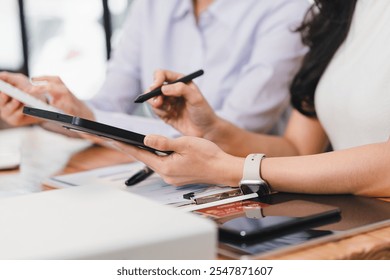 Collaborative work on tablet, showcasing teamwork and productivity. individuals are engaged in discussion, using digital tools for effective communication.