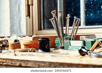 collage of horological tools, wood, and metal occupies the bench, the watchmaker's canvas - Powered by Shutterstock