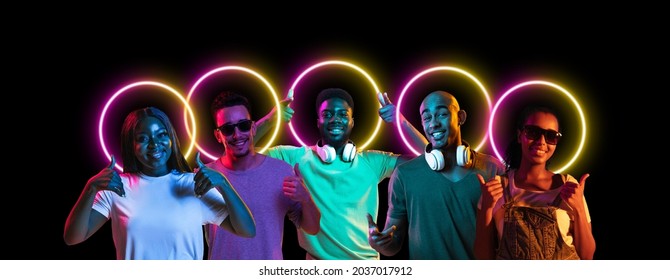 Collage Made Of Multiethnic Young People Standing Together Isolated On Dark Studio Background In Multicolored Neon Light With Geometric Luminescent Shape Cirlce. Unity, Diversity, Youth, Ad