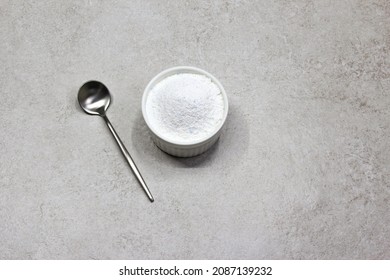 Collagen powder on grey beton background. Extra protein intake. Natural beauty and health supplement for skin, bones, joints and gut. Plant or fish based. Flatlay, top view. Copy space