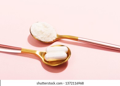 Collagen powder and pills on pink background. Extra protein intake. Natural beauty and health supplement for skin, bones, joints and gut. Plant or fish based. Flatlay, top view. Copy space.