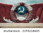 The collapse of the USSR. Coat of arms that is cracked from time, dirty and with drops of paint. Artifact of history. No war