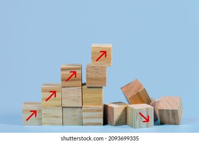 Collapsed stair structure of wooden cubes with upward pointing arrows, business risk due to inflation, crisis, supply shortage or unsustainable financial concept, blue background with copy space