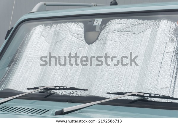 Collapsed sun shade or sun reflector on the\
windshield the car