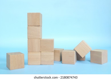 Collapsed Wooden Building Blocks In Blue Background. Weak Foundation And Built Conceptual.