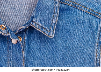 Collar on denim women's shirt, close up. Double simple straight stitch with orange thread on denim, fashion background, text place. - Shutterstock ID 741832264