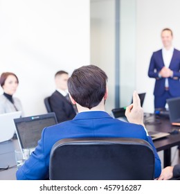 Colleague asking a question to  businessman during a presentation. Successful team leader and business owner  leading informal in-house business meeting. Business and entrepreneurship concept.