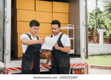 Colleague documents while the delivery man unloads boxes. Teamwork in the removal company ensures efficient transportation bringing smiles to relocation. Moving Day