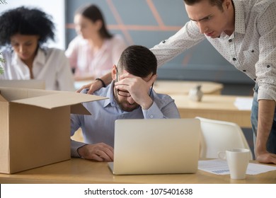 Colleague supporting dismissed depressed male employee got fired on last working day, upset frustrated office worker preparing to pack box leave workplace feeling stressed about losing job concept