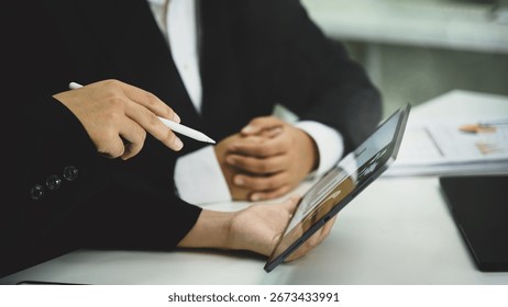 Colleagues analyzing financial data and workflow charts with digital tablet in an office