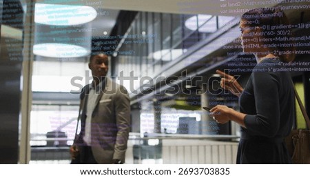 Colleagues in businesswear analyzing code on display in atrium, smartphone, messenger bag. Corporate, technology, innovation, futuristic, collaboration, modern, digital