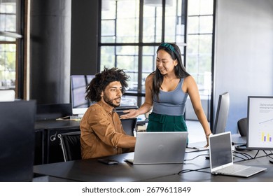 Colleagues collaborating on project using laptops in modern office setting. Coworkers, teamwork, brainstorming, technology, innovation, business