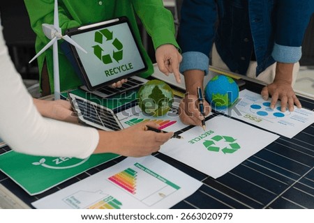 colleagues discussing data working and tablet, laptop with on Construction Site project, green energy and solar panel concept.