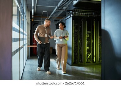 Colleagues Discussing Work while Walking in Server Room