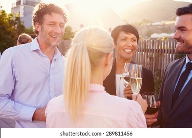 Colleagues drinking after work at a rooftop bar - Powered by Shutterstock