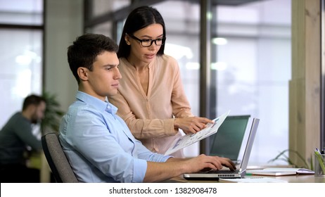 Colleagues entering data from graphs into computer to check growth and decline - Shutterstock ID 1382908478