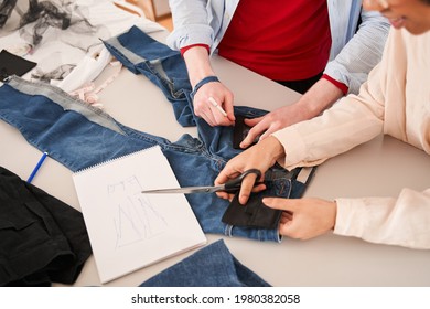 Colleagues Examining Jeans And Drawing Sketches While Re Sewing Old Clothes