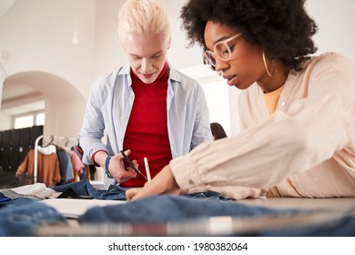 Colleagues Examining Jeans And Drawing Sketches While Re Sewing Old Clothes