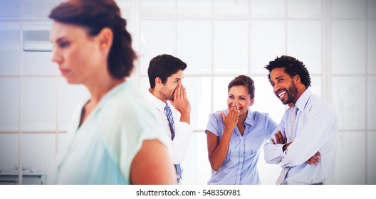 Colleagues gossiping with sad young businesswoman in foreground at a bright office - Shutterstock ID 548350981