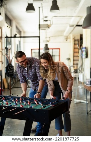 Colleagues having fun at work. Businessman and businesswoman playing table soccer	 Foto stock © 