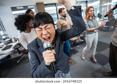 Colleagues having karaoke party in the office  - Powered by Shutterstock