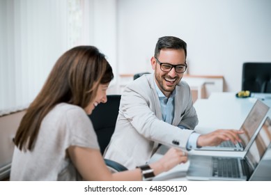 Colleagues Laughing Together In Office During Work