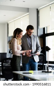 Colleagues In Office. Businesswoman And Businessman Discussing Work In Office. Two Friends Working Together	