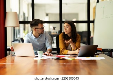 Colleagues in office. Businesswoman and businessman discussing work in office - Shutterstock ID 2208305043