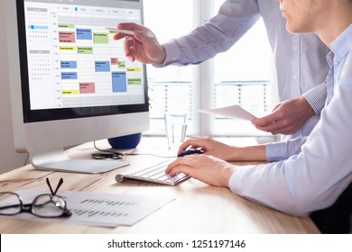 Colleagues planning a meeting with calendar software on computer, search time slot between events, tasks, and appointments, busy business people using time management tool to organize work, office - Shutterstock ID 1251197146