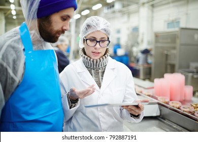 Colleagues From Seafood Processing Plant Discussing Online Data About Canned Food