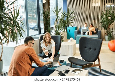 colleagues sitting in chairs, discussing work in a modern business setting with a startup team vibe.