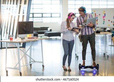 Colleagues using digital tablet and laptop in office - Powered by Shutterstock