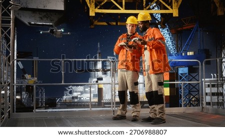 Colleagues using drone to collect data for offshore platform evaluation, inspection and environmental monitoring to enhance safety and efficiency in petroleum extraction.