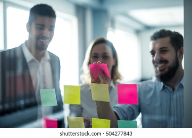 Colleagues using sticky notes for their business schedule. - Shutterstock ID 504277843