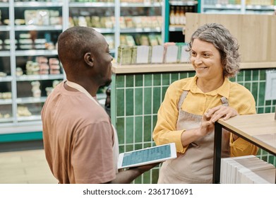 Colleagues using tablet pc in supermarket - Powered by Shutterstock