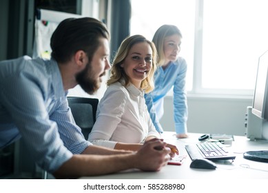 Colleagues Working Together On A Computer In An Office.