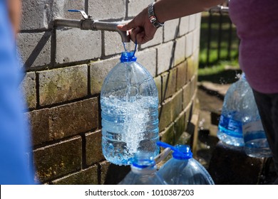 Collecting Natural Spring Water With 5 Litre Plastic Water Bottle At Newlands Natural Spring Cape Town South Africa 
