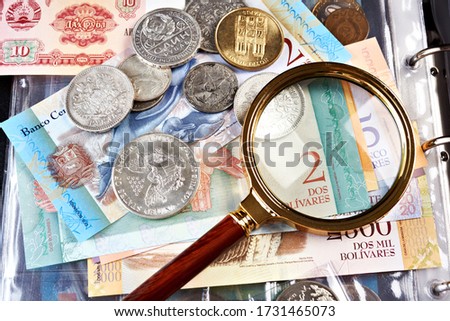 Collecting old coins and banknotes. Numismatics. Old money and notes with magnifying glass